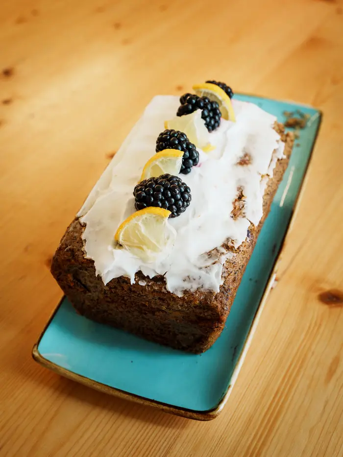 Zitronen-Brombeer-Rührkuchen mit Zuckerguss und frischen Brombeeren.