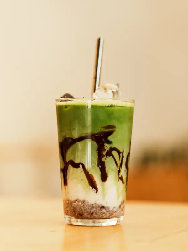 Matcha Oreo Latte im Glas mit Schoko-Keks-Schicht und Matcha.