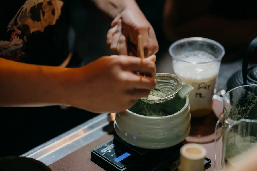 Nahaufnahme: Zubereitung eines Matcha Latte am Nyanko-Stand.
